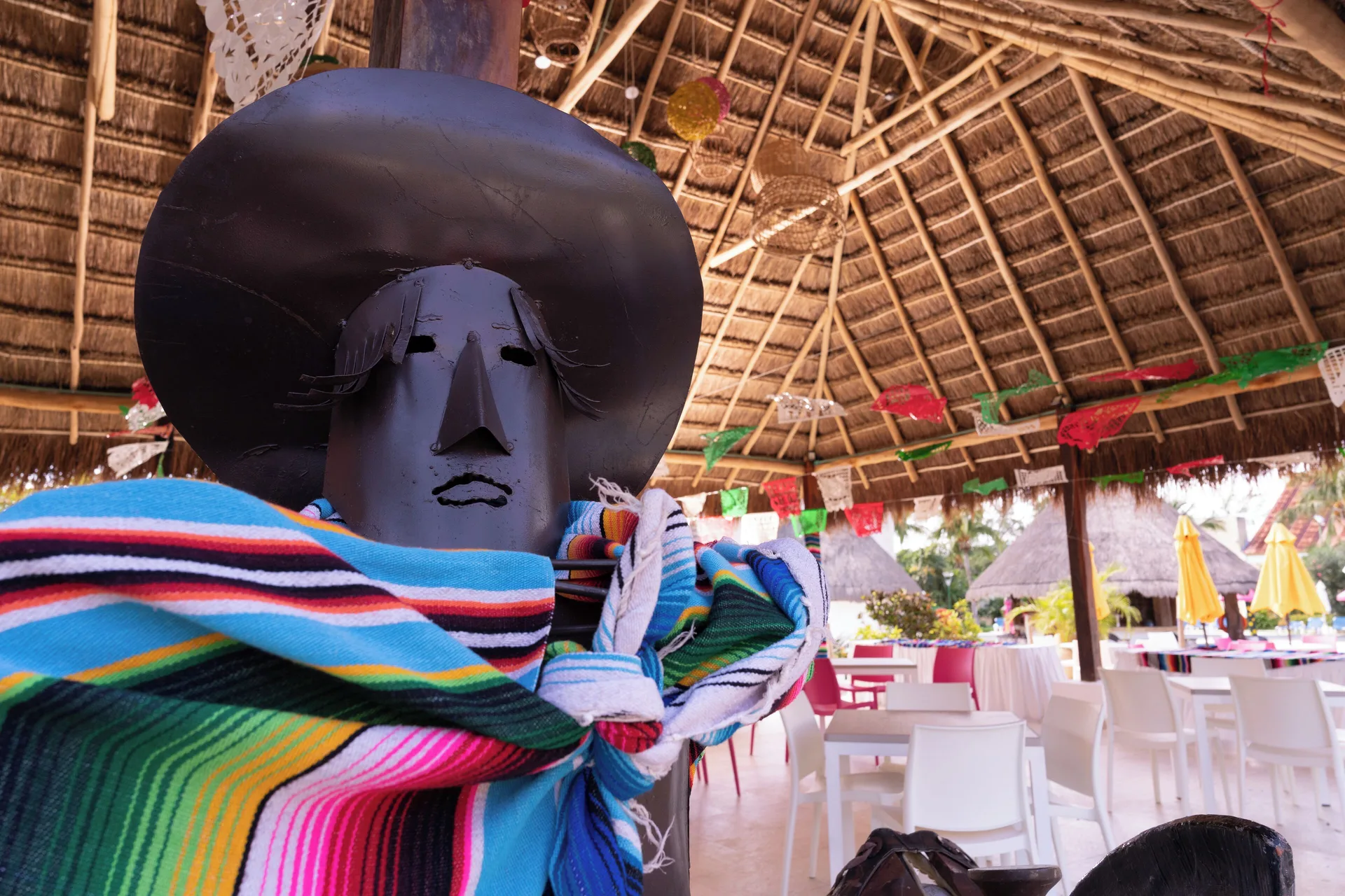 Mexican-style decorative figure under a palapa at All Ritmo Cancun Resort & Water Park.
