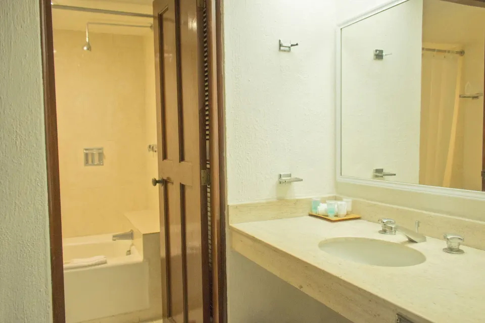 Junior Suite Sea View bathroom vanity and tub at All Ritmo Cancun Resort & Water Park.