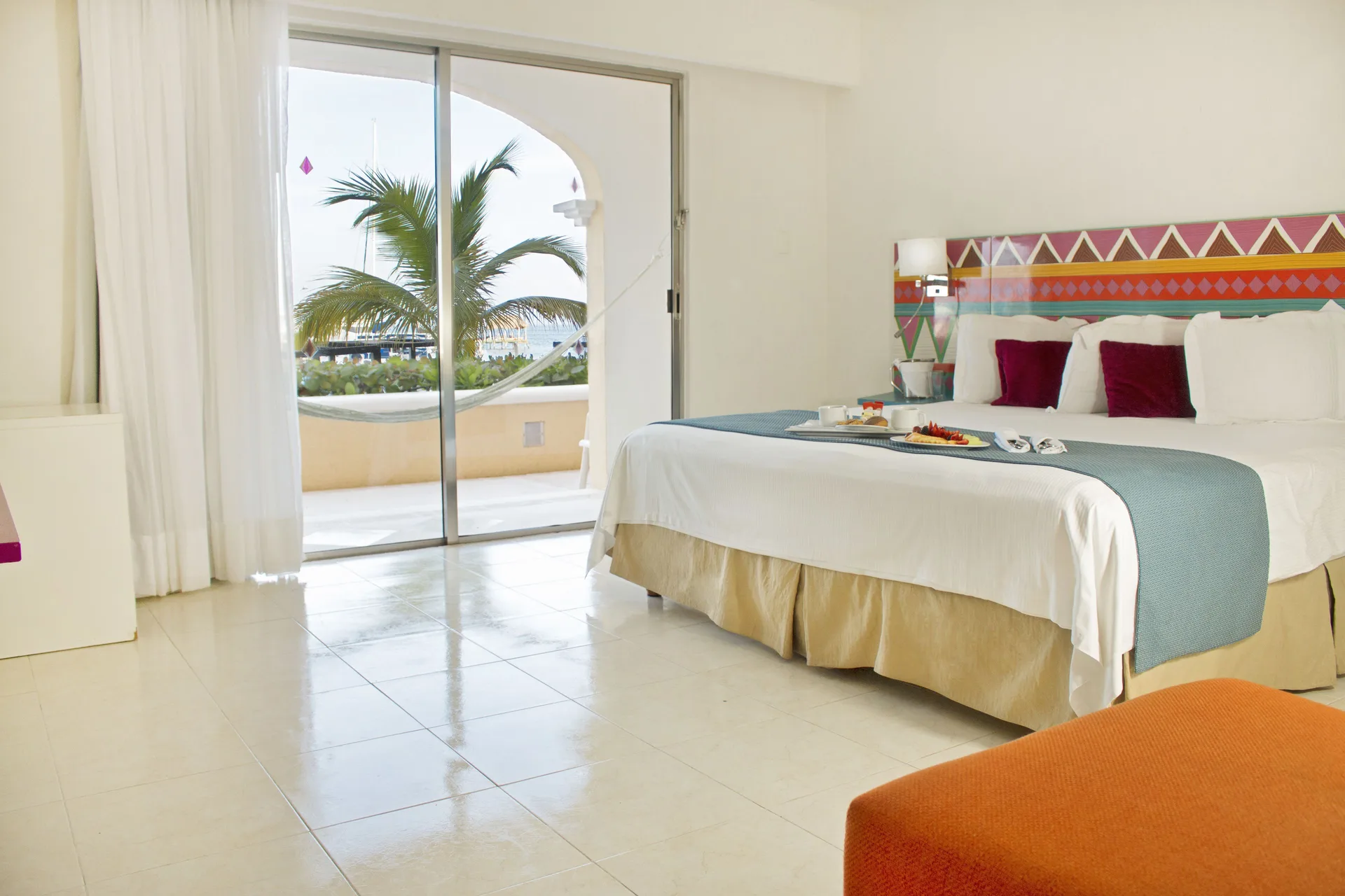 Junior Suite Sea View king bed and balcony hammock at All Ritmo Cancun Resort & Water Park.