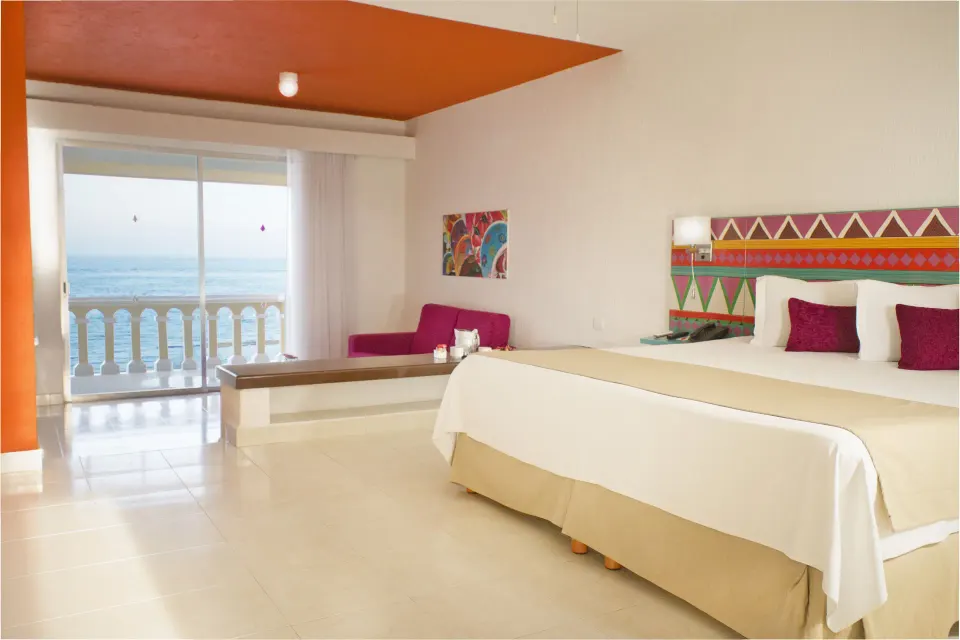 Junior Suite Sea View king bed and ocean-facing balcony at All Ritmo Cancun Resort & Water Park.