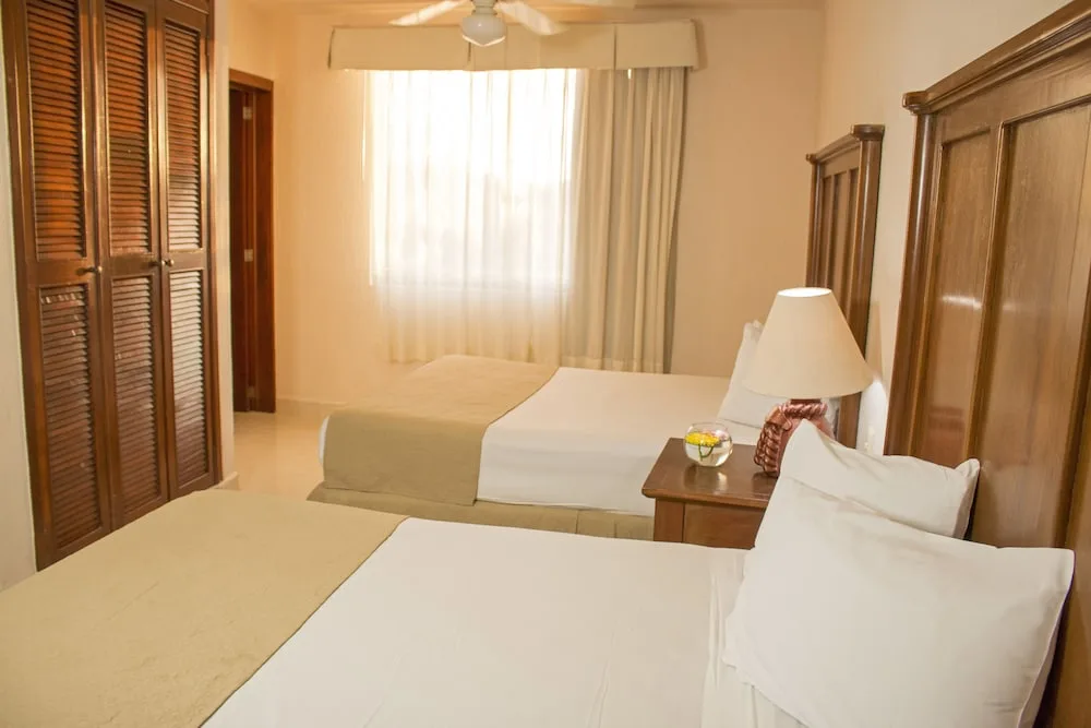Standard Room with two beds and louvered closet doors at All Ritmo Cancun Resort & Water Park.