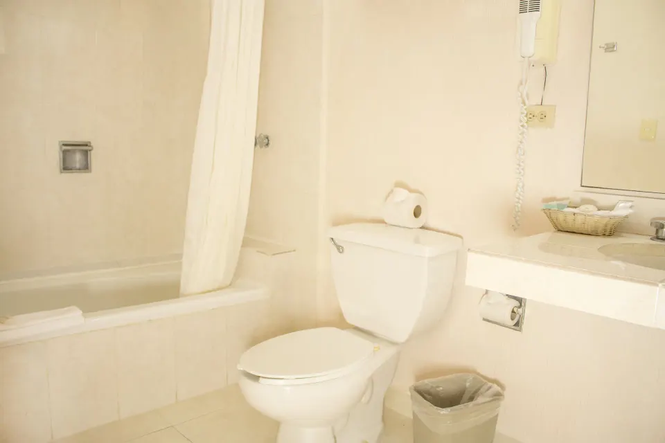 Standard room bathroom with tub, toilet, and vanity at All Ritmo Cancun Resort & Water Park.