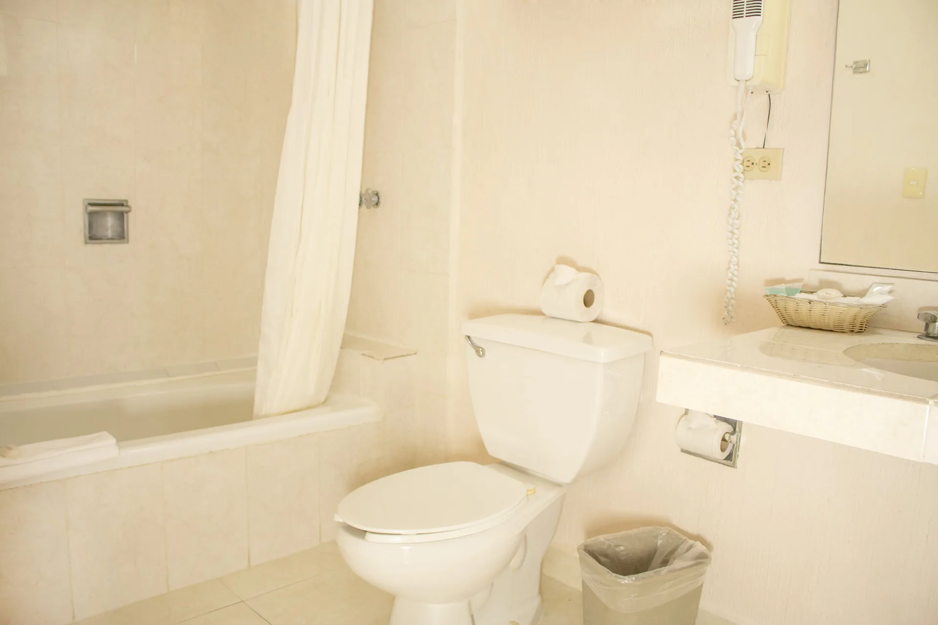 Standard room bathroom with tub, toilet, and vanity at All Ritmo Cancun Resort & Water Park.