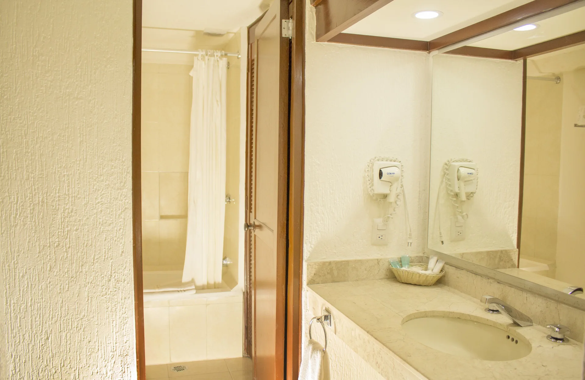 Standard room bathroom vanity and tub area at All Ritmo Cancun Resort & Water Park.
