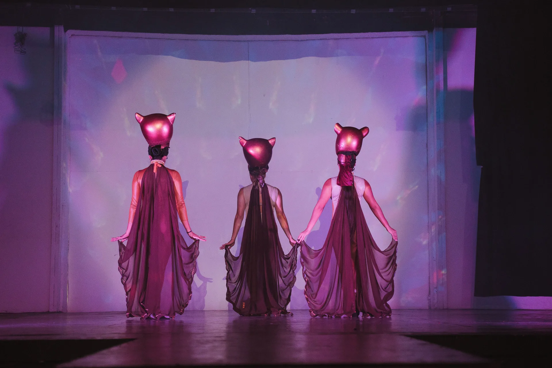 Costumed stage performers under purple lighting at All Ritmo Cancun Resort & Water Park.