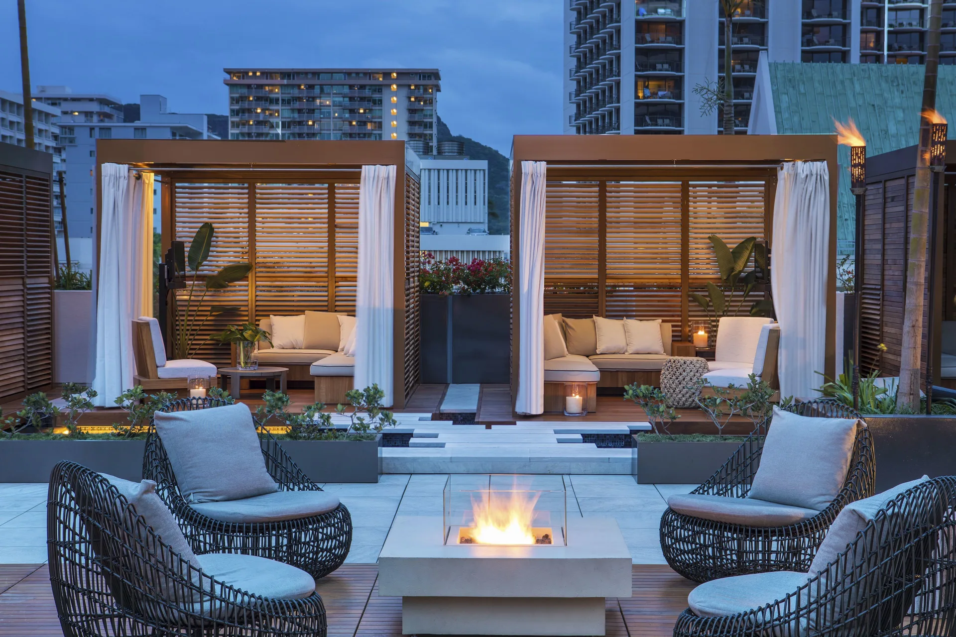 Private-style cabanas and fire feature at 'Alohilani Resort Waikiki Beach.