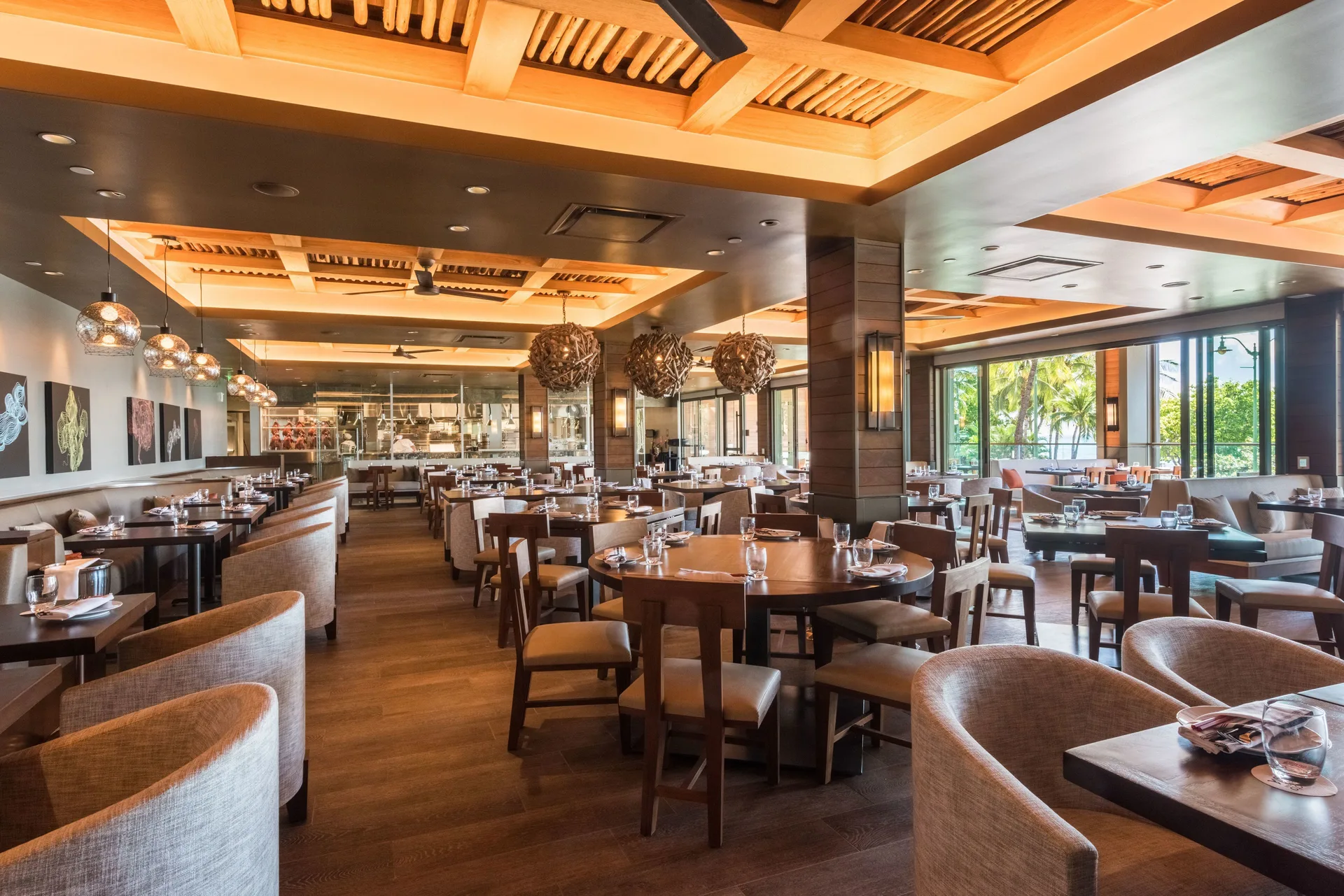 Dining room with set tables and warm wood ceiling at 'Alohilani Resort Waikiki Beach.