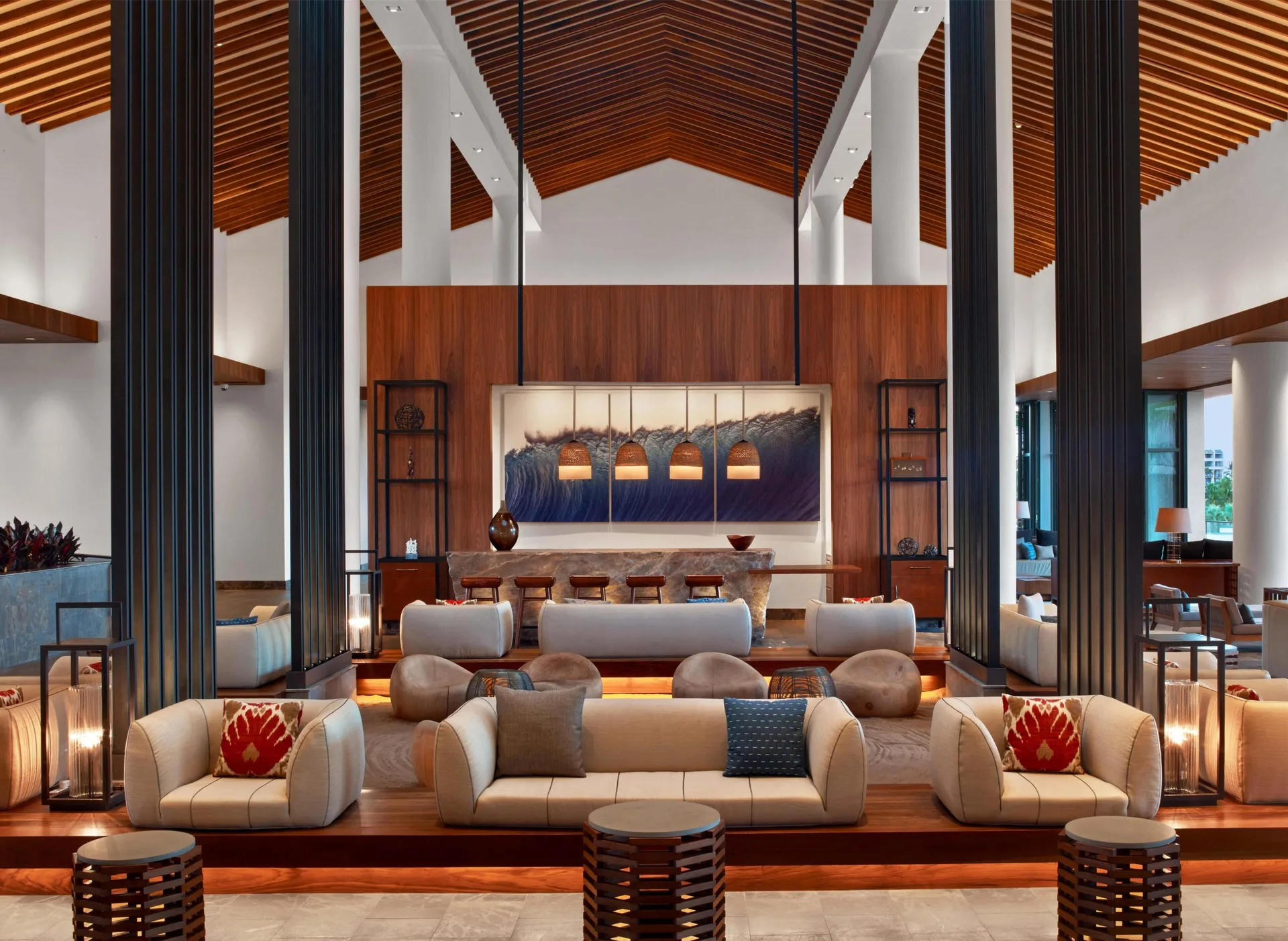 Lobby seating with wave artwork and pendant-lit bar at Andaz Maui at Wailea Resort.