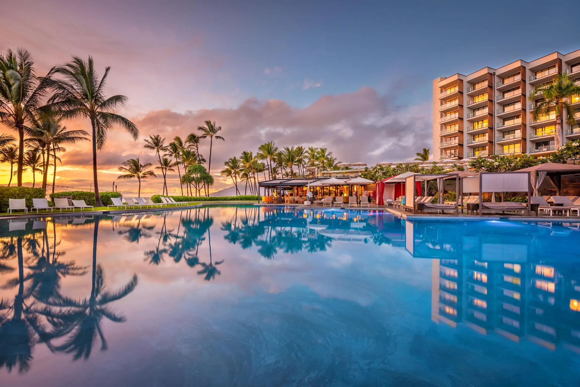 Sunset pool with palm reflections and resort tower at Andaz Maui at Wailea Resort.