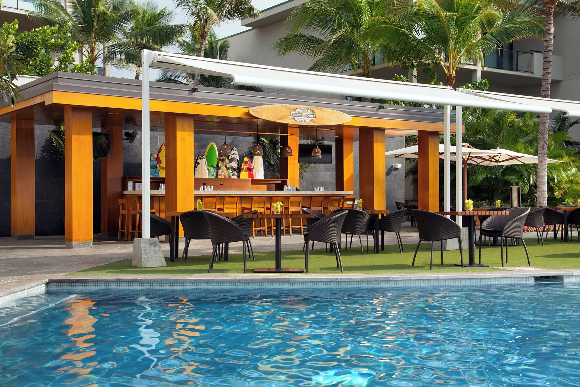 Poolside bar with tables beside the water at Andaz Maui at Wailea Resort.