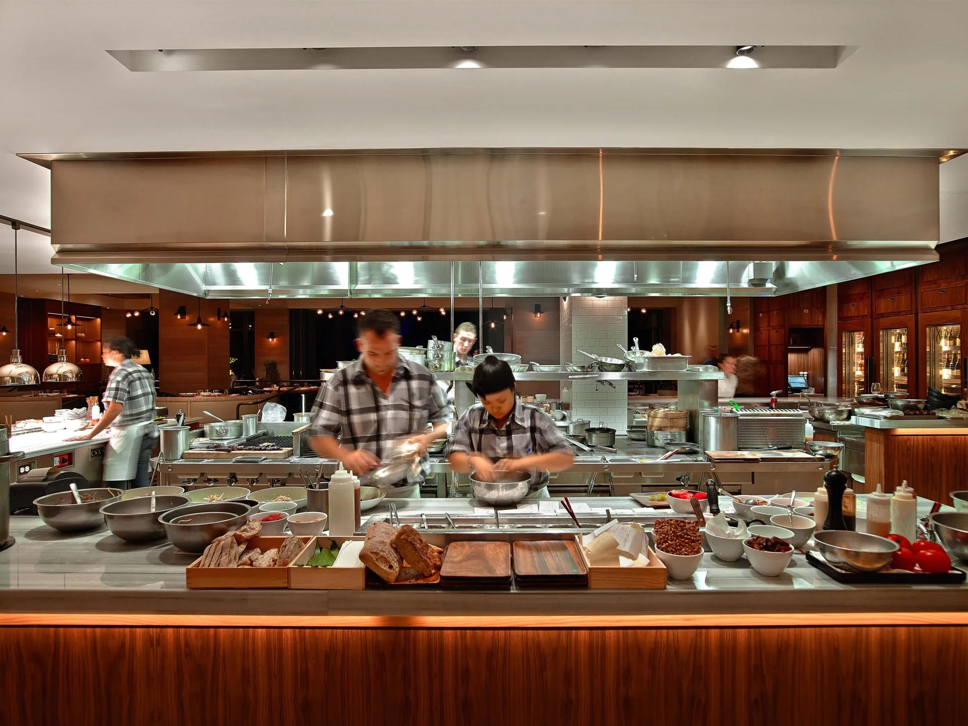 Chefs work at an open kitchen counter at Andaz Maui at Wailea Resort.