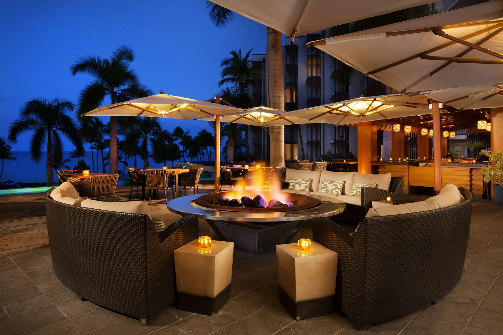Outdoor lounge seating around a fire pit at dusk at Andaz Maui at Wailea Resort.