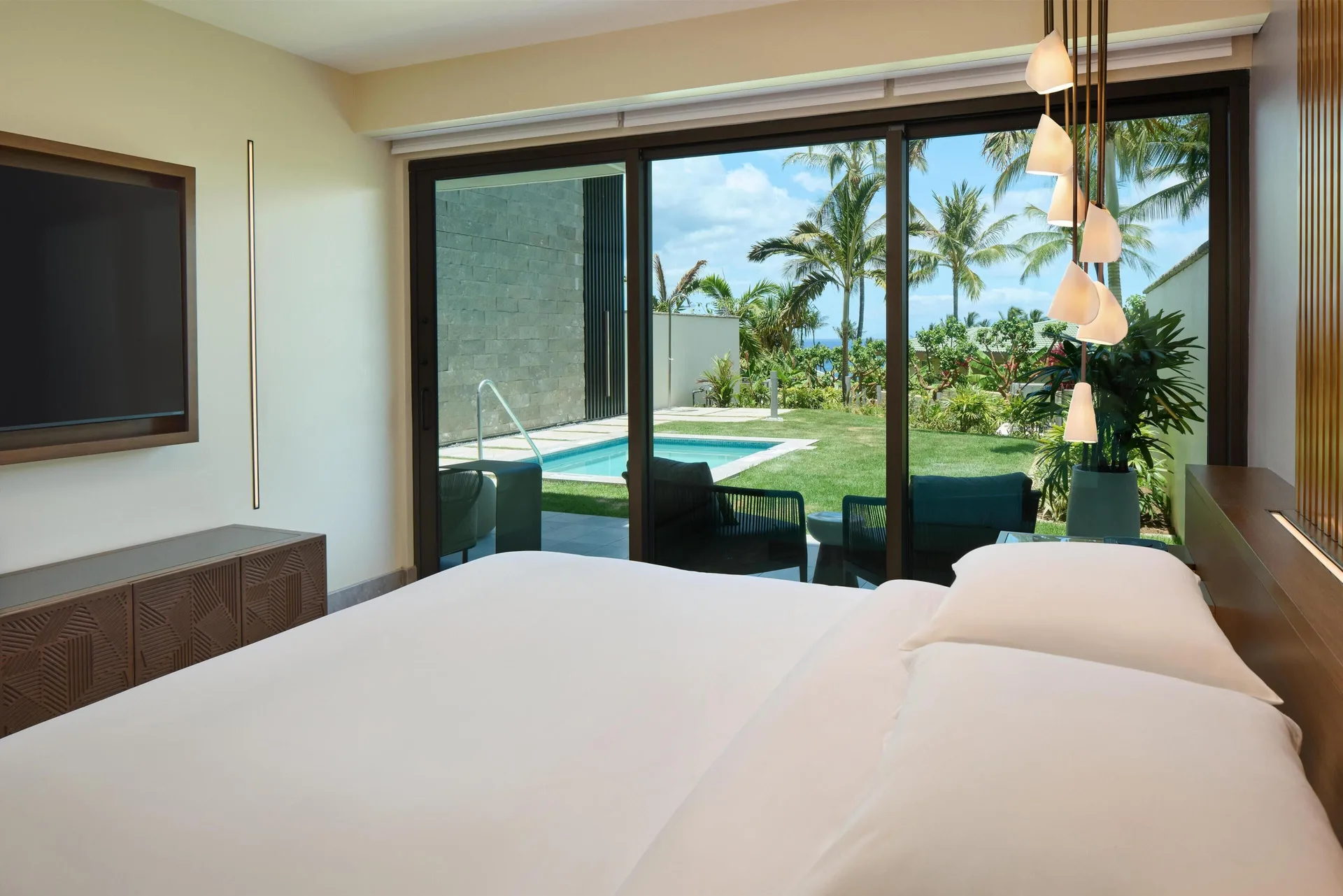Bedroom opening to a pool and garden in the 3 Bedroom Ilikai Villa at Andaz Maui at Wailea Resort.