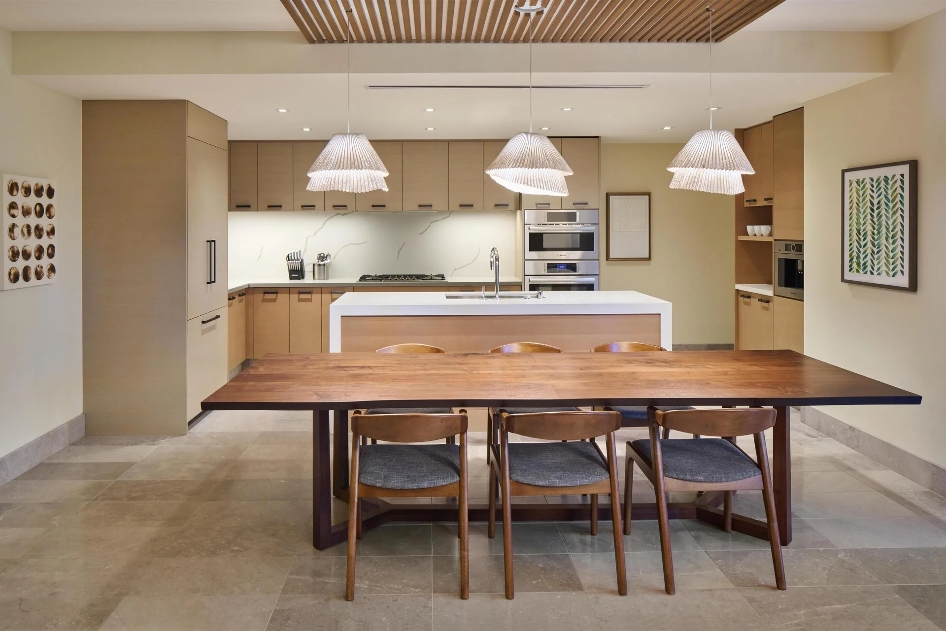 Dining table and kitchen in the 3 Bedroom Ilikai Villa at Andaz Maui at Wailea Resort.