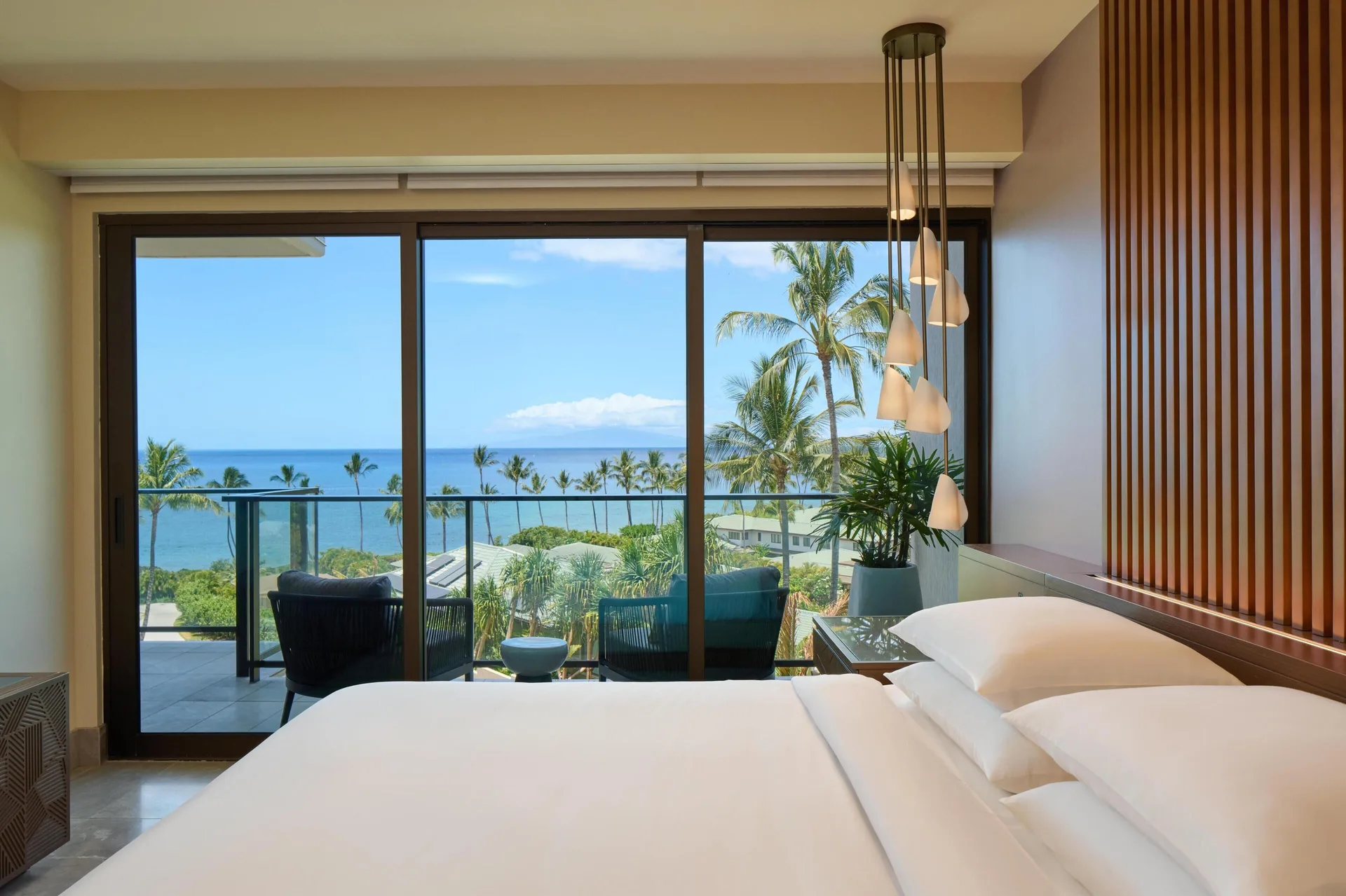 Ocean-view villa bedroom with white bedding and balcony at Andaz Maui at Wailea Resort.