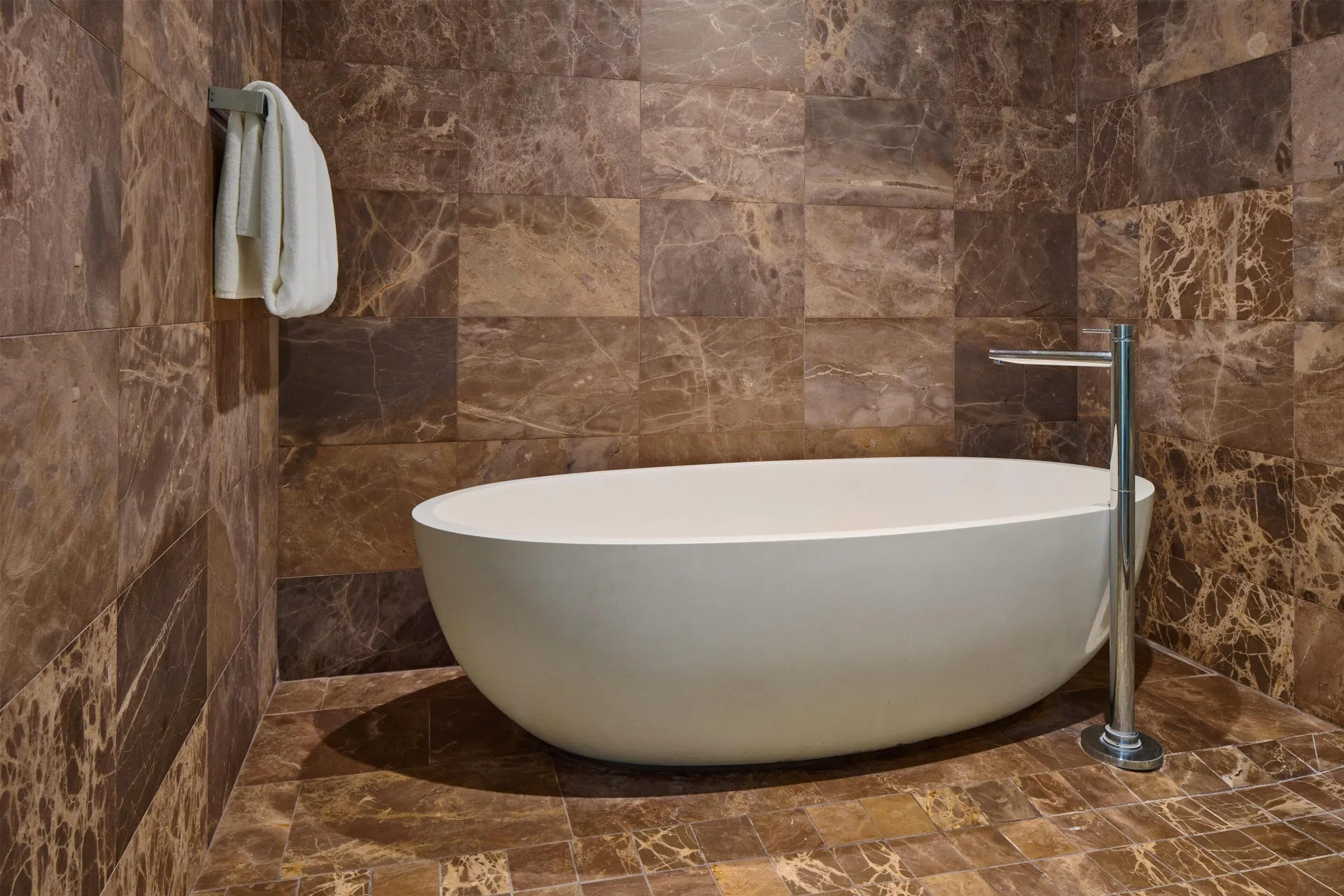 Villa bathroom with freestanding tub and stone tile walls at Andaz Maui at Wailea Resort.