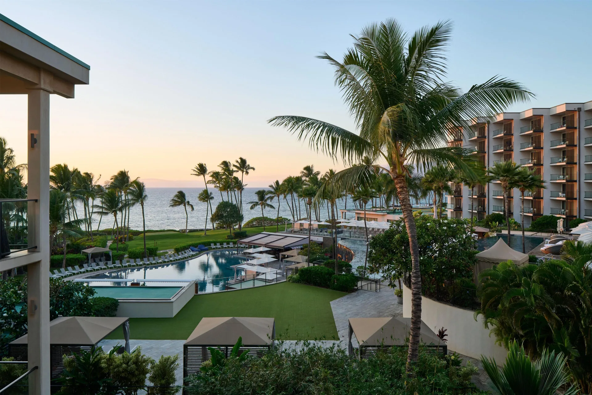 Ocean, pools, palms, and resort buildings seen from a villa at Andaz Maui at Wailea Resort.