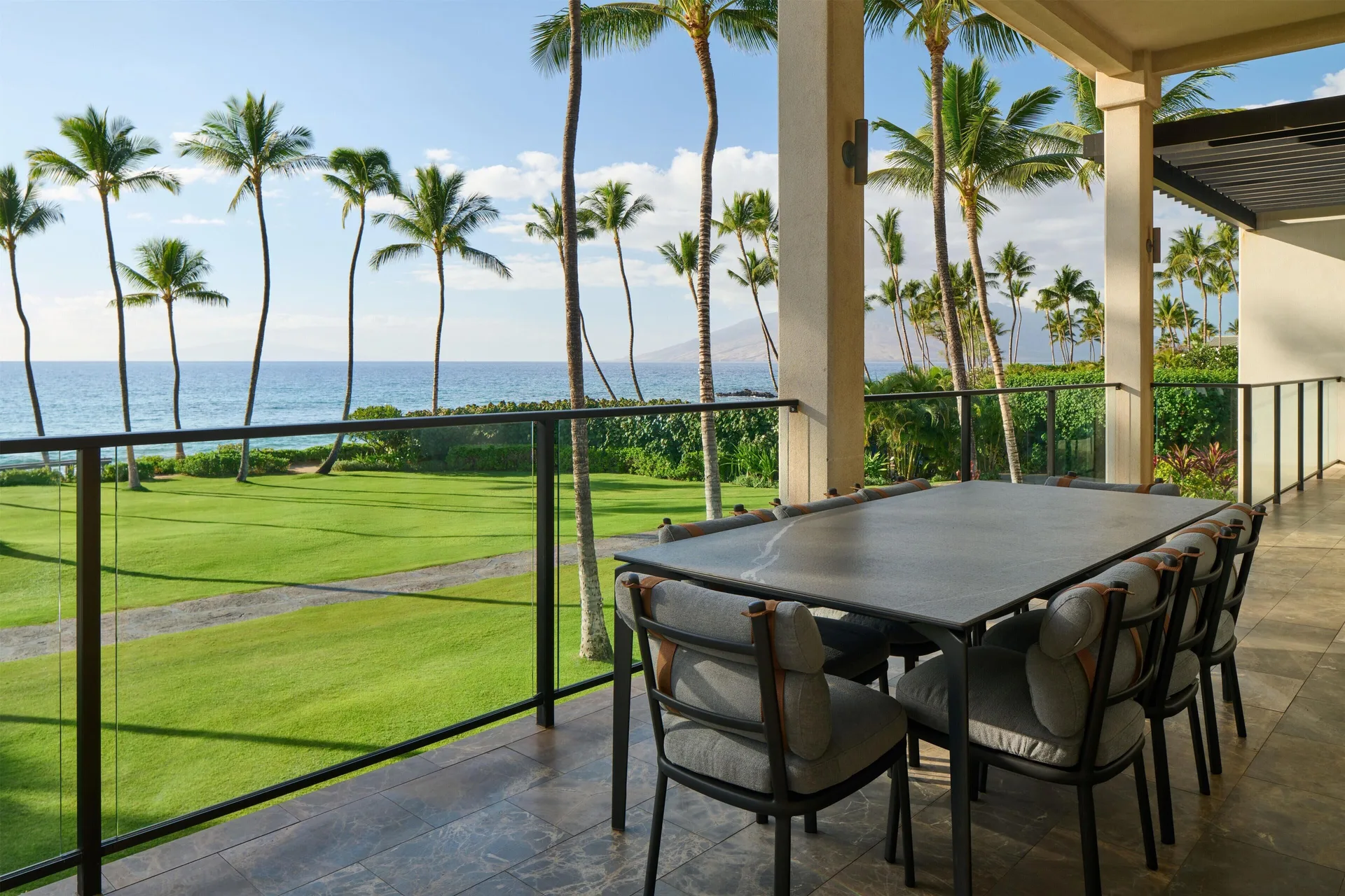 Oceanfront villa balcony dining table with ocean and palm views at Andaz Maui at Wailea Resort.