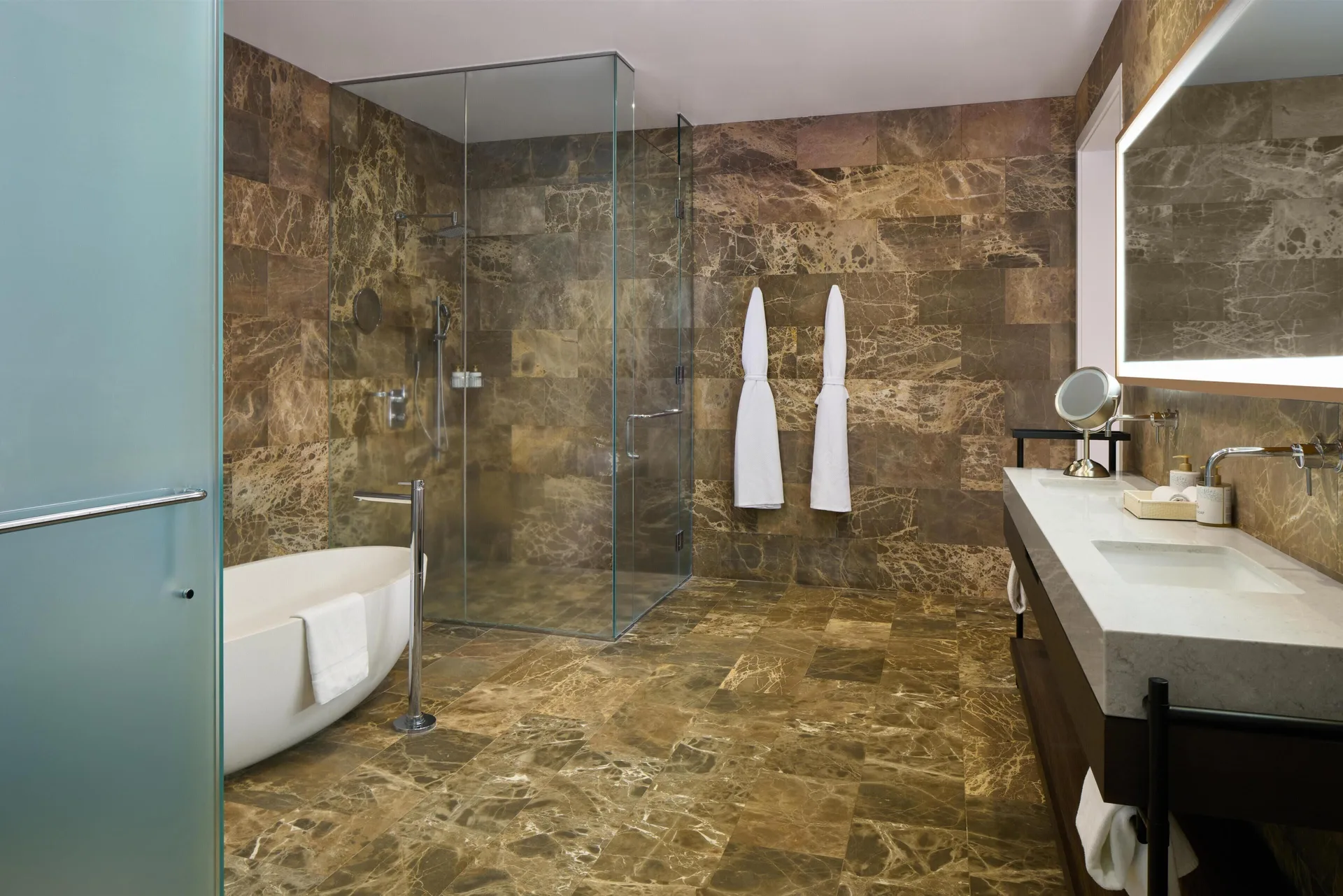 Stone-tiled villa bathroom with tub, shower, and vanity at Andaz Maui at Wailea Resort.