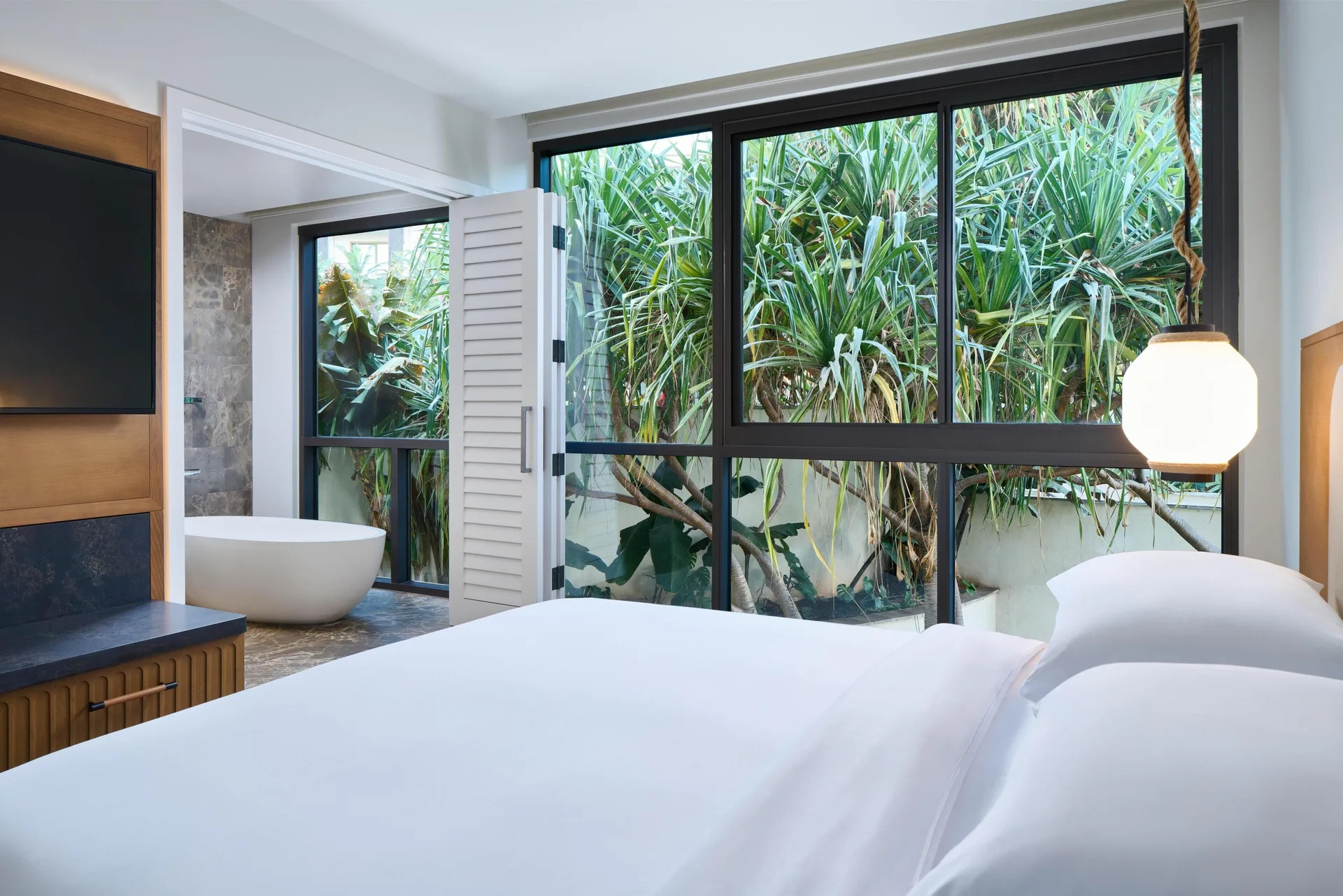 Bedroom with a king bed, garden-facing windows, and open bathroom at Andaz Maui at Wailea Resort.