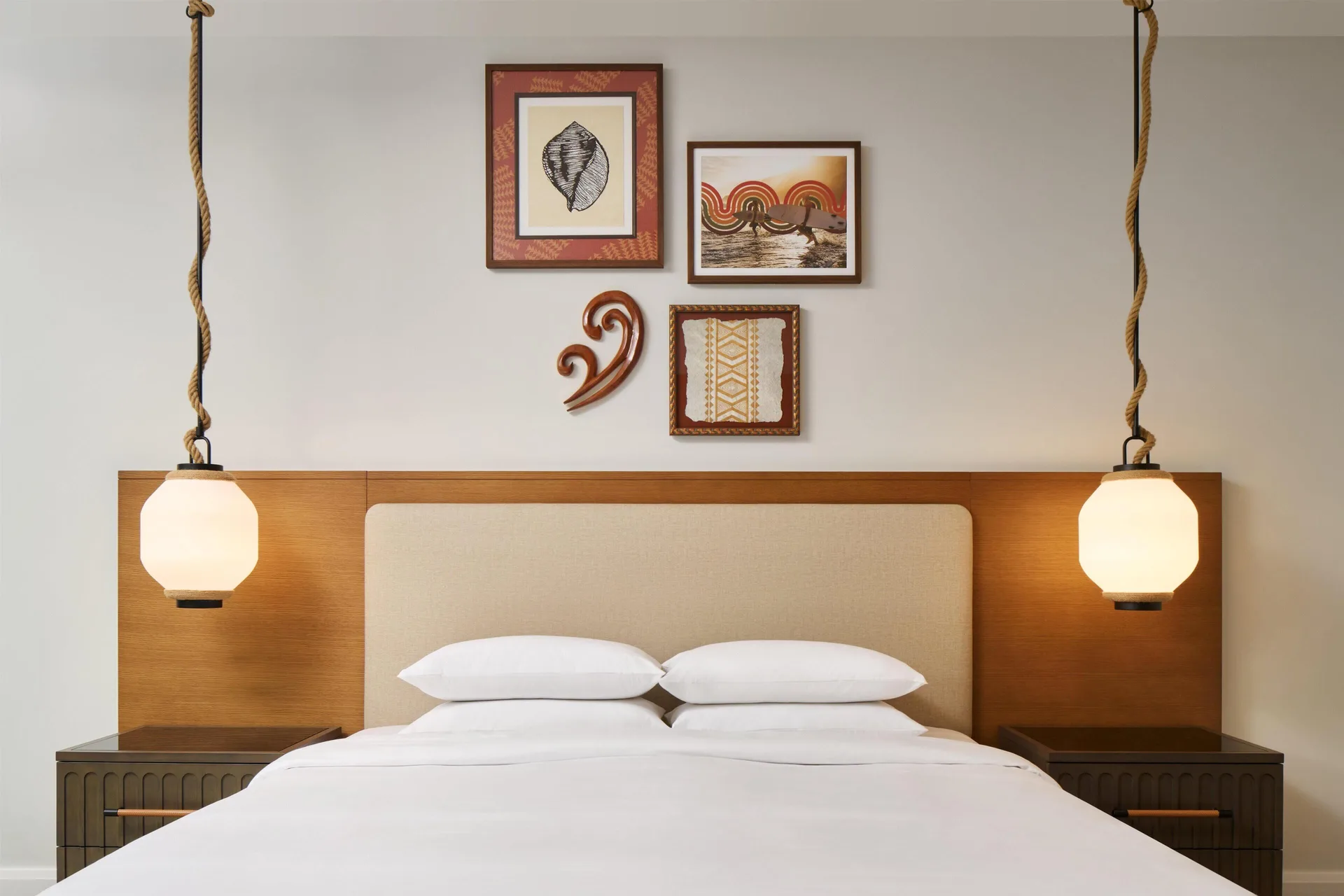 Bedroom with a king bed and framed wall art in an oceanfront villa at Andaz Maui at Wailea Resort.