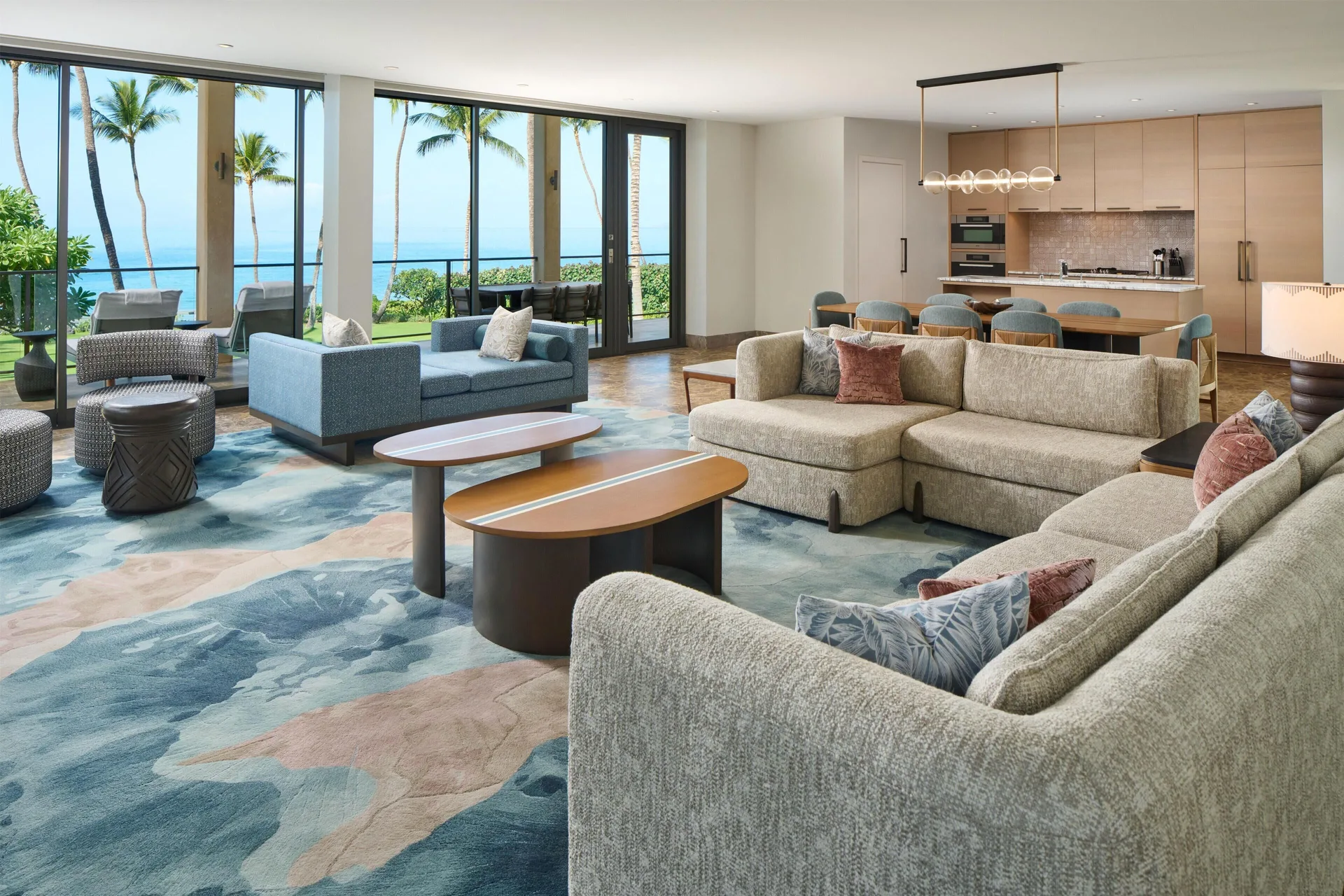 Oceanfront villa living room with sofas, kitchen, and ocean view at Andaz Maui at Wailea Resort.