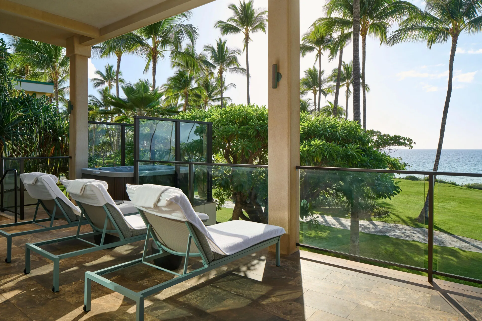 Oceanfront villa terrace lounge chairs and hot tub with ocean view at Andaz Maui at Wailea Resort.