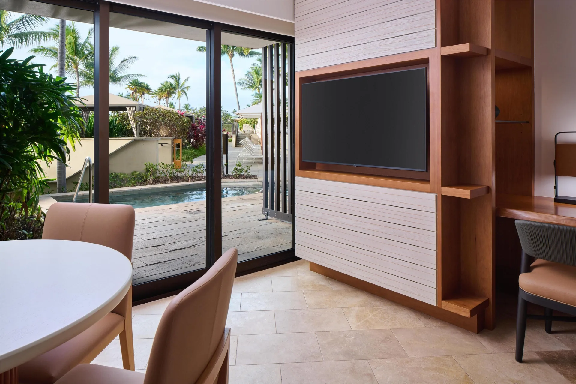 Pool Side Suite living area with TV, dining table, and poolside doors at Andaz Maui at Wailea Resort.