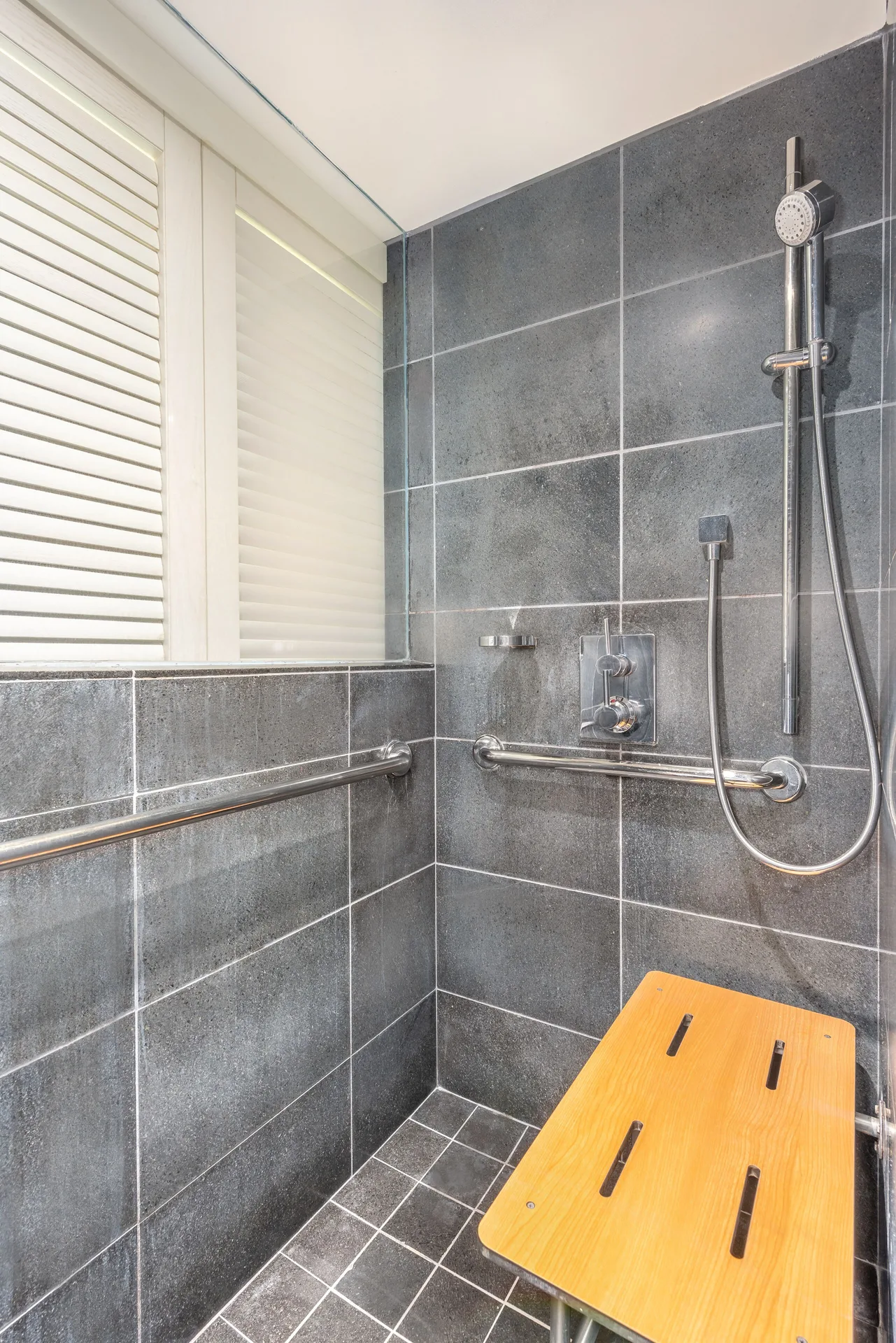 ADA ocean view room shower with grab bars and bench at Andaz Maui at Wailea Resort.