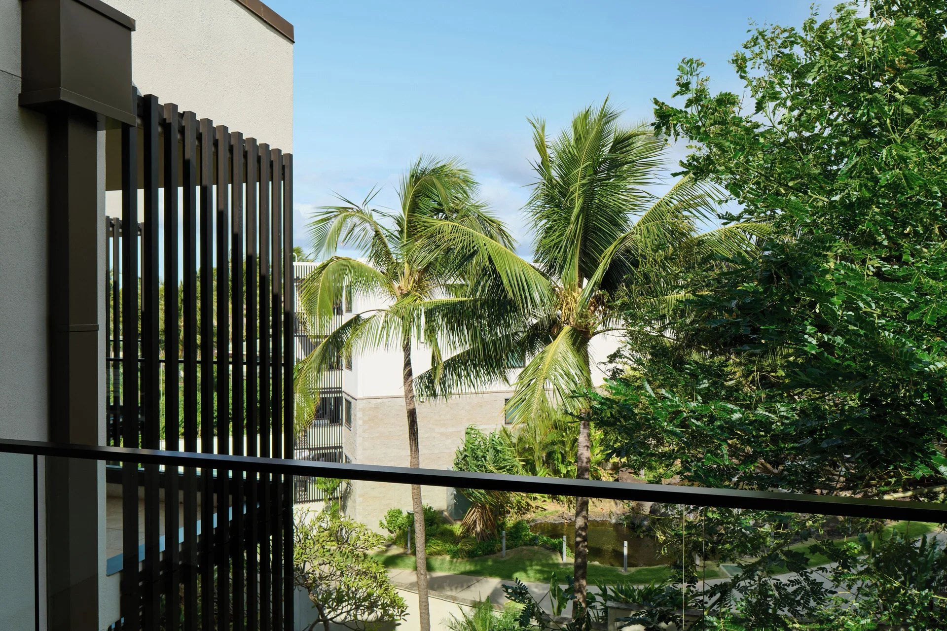 Resort view room balcony with palms and hotel buildings at Andaz Maui at Wailea Resort.