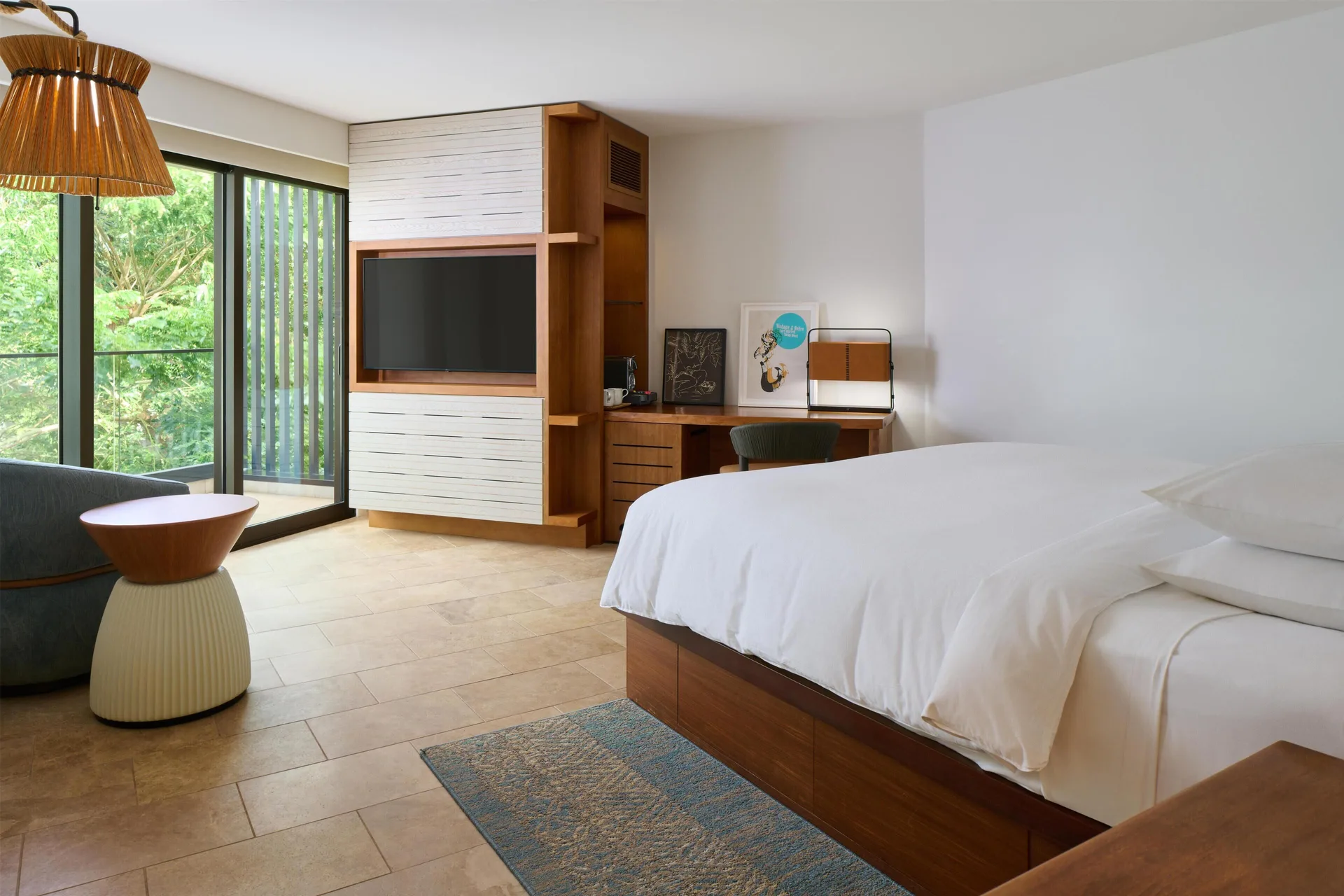 King bed, TV wall, desk, and balcony greenery in a resort view room at Andaz Maui at Wailea Resort.