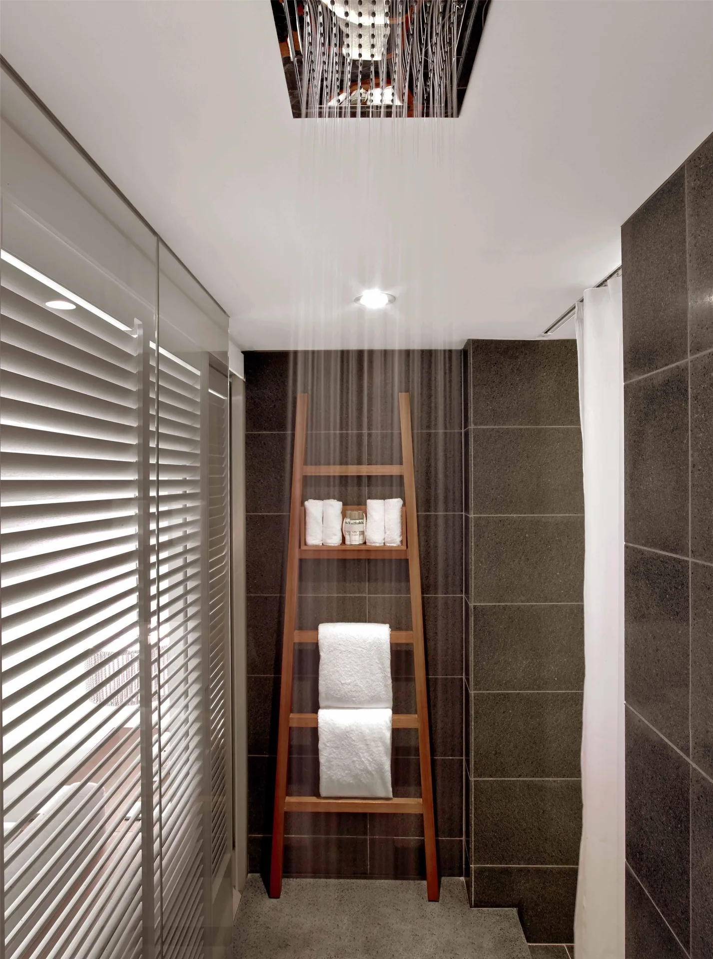 Rain shower and towel ladder in a resort view room bathroom at Andaz Maui at Wailea Resort.