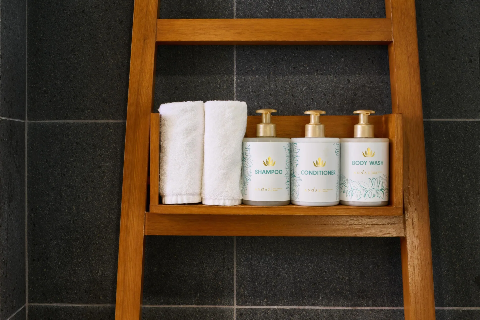 Resort view room shower shelf with towels and bath amenities at Andaz Maui at Wailea Resort.
