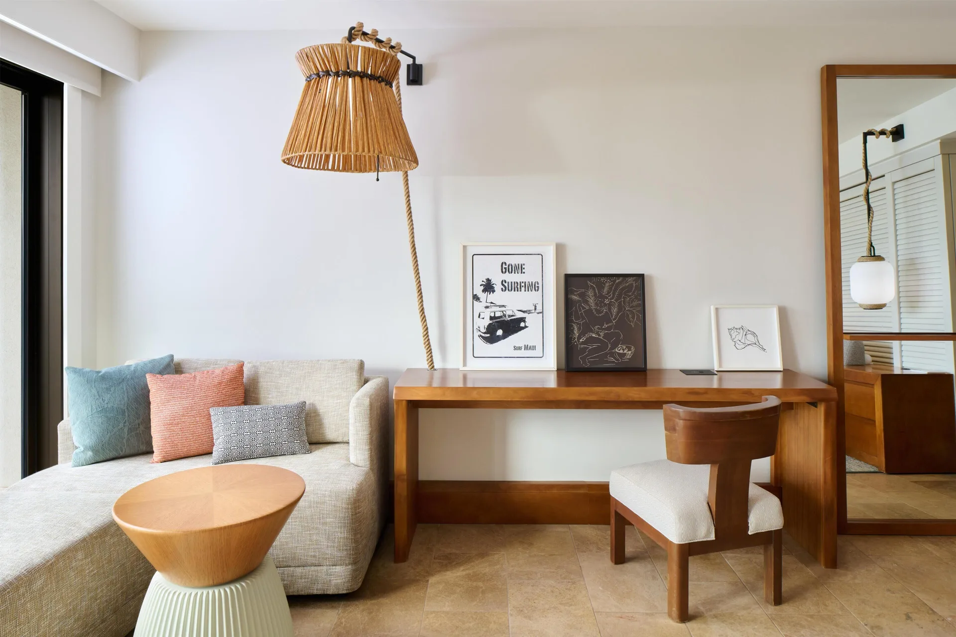 Sofa, desk, mirror, and rattan lamp in a resort view room at Andaz Maui at Wailea Resort.