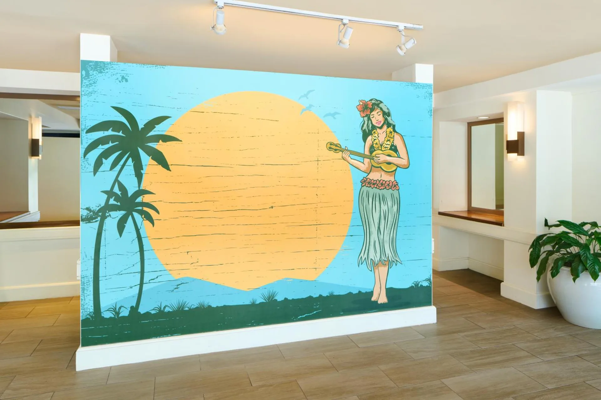 Lobby mural with palm trees, sunset and hula figure at Aqua Palms Waikiki.