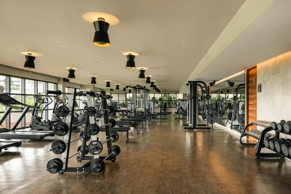 Fitness center with cardio machines, weights, and mirrors at Atelier Playa Mujeres.