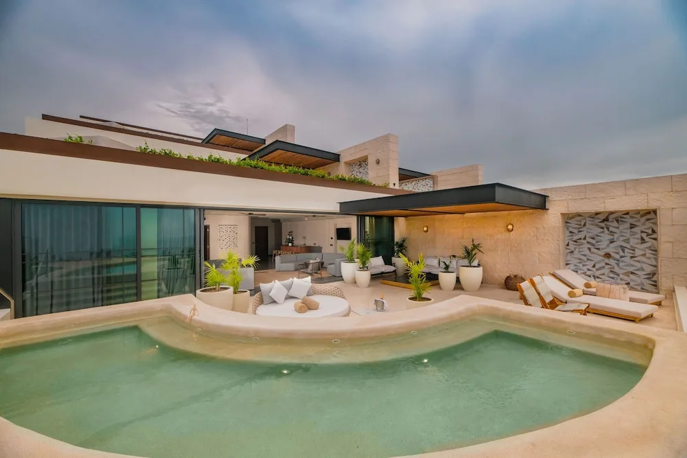 Private terrace plunge pool with loungers and seating at Atelier Playa Mujeres.