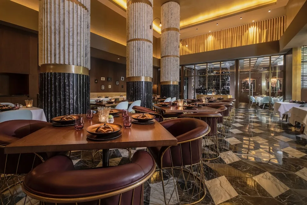 Dramatic restaurant dining room with marble floor at Atelier Playa Mujeres.