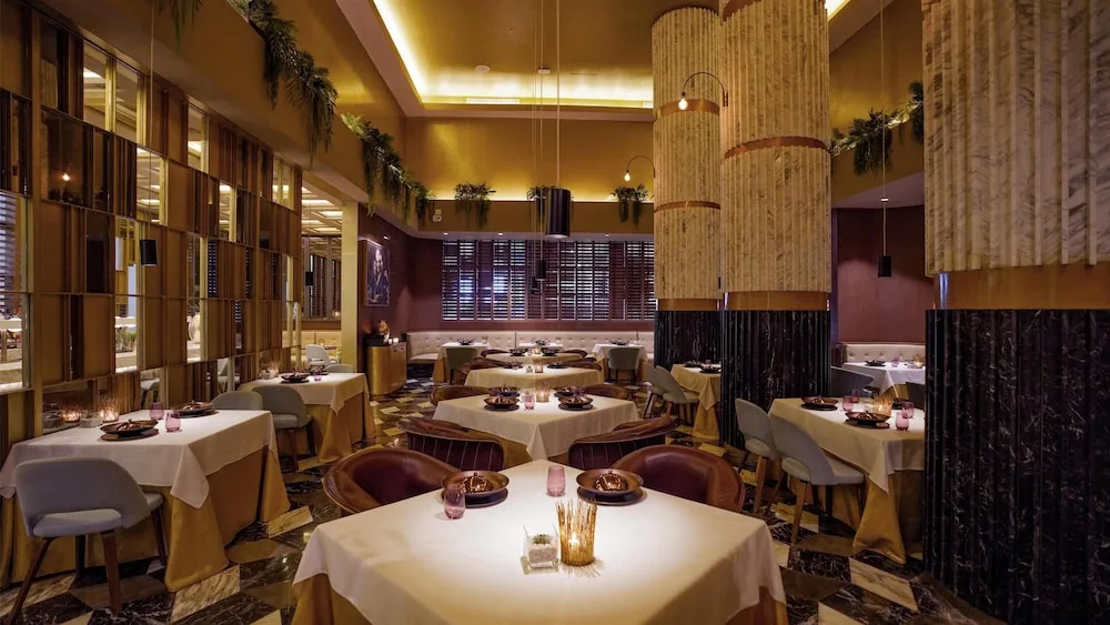 Elegant restaurant dining room with round tables at Atelier Playa Mujeres.