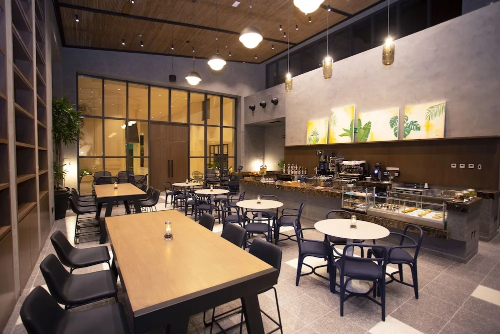 Indoor café seating and pastry counter at Atelier Playa Mujeres.