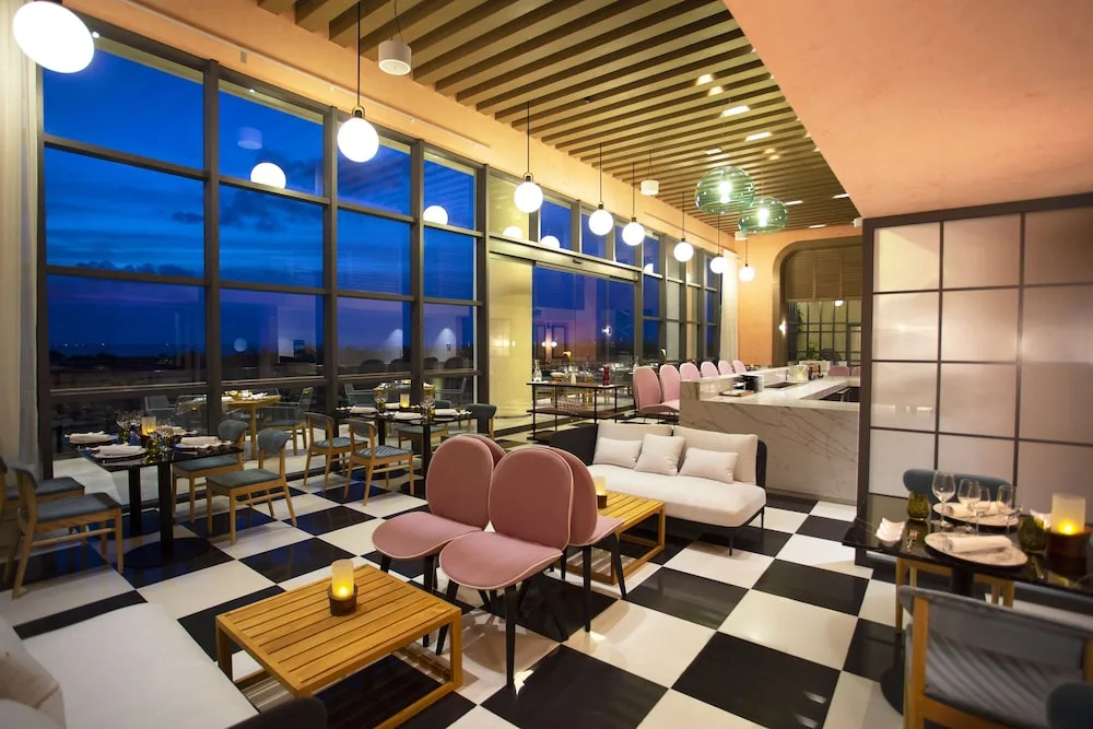 Modern restaurant with checkered floor and sunset windows at Atelier Playa Mujeres.