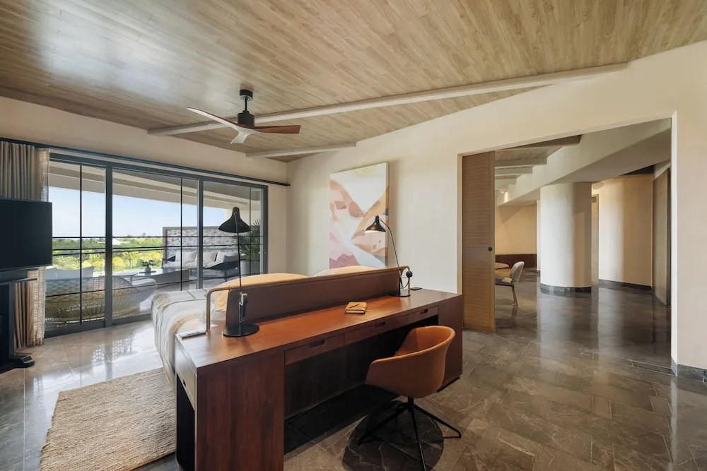 Inspira Business Suite bedroom with desk, king bed and balcony doors at Atelier Playa Mujeres.