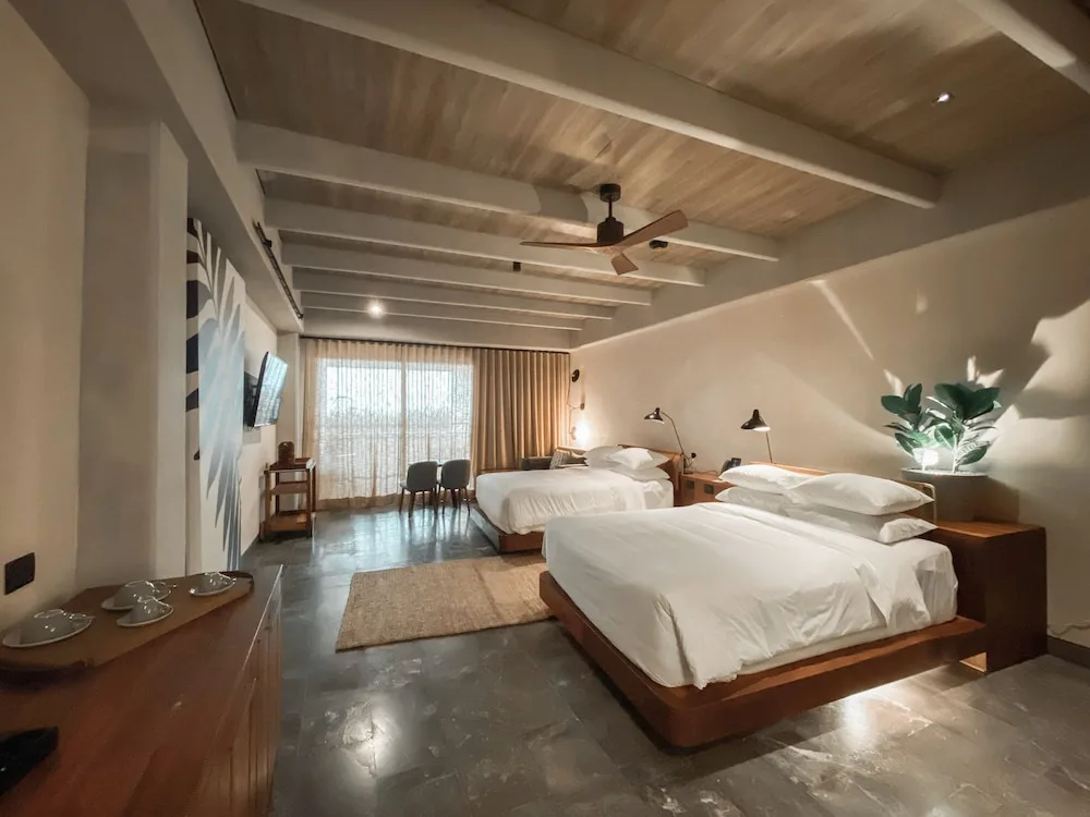 Inspira Corner Suite with two beds and seating at Atelier Playa Mujeres.