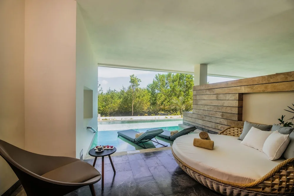 Inspira Junior Suite Swim Out patio with daybed and loungers at Atelier Playa Mujeres.