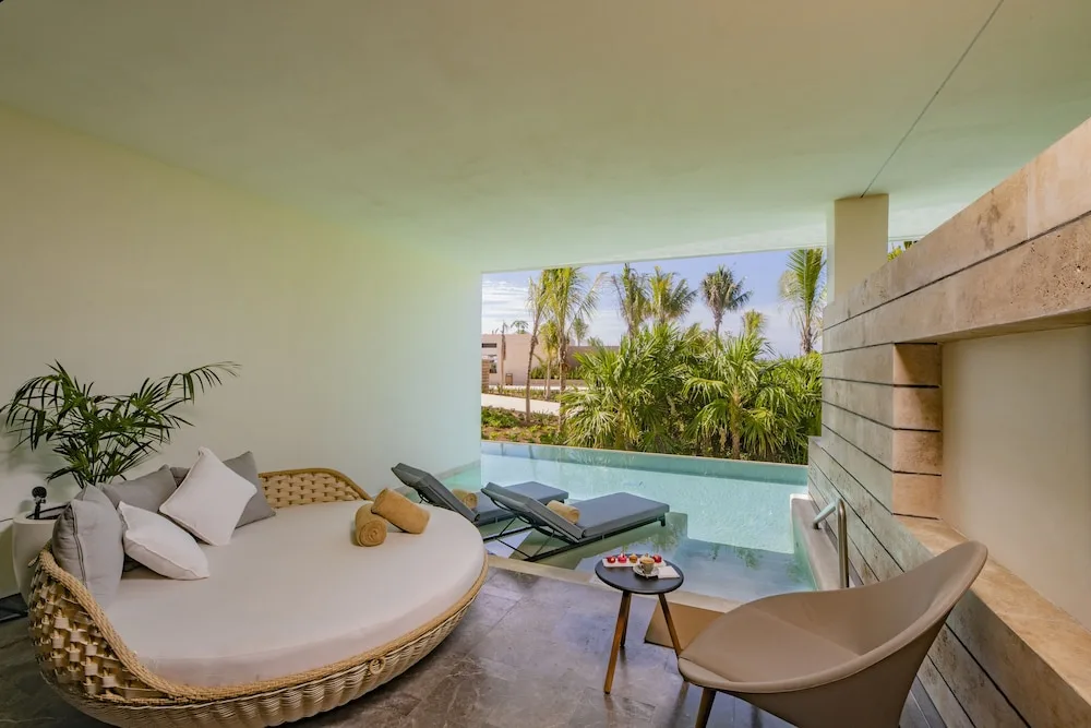 Inspira Junior Suite Swim Out terrace with daybed and pool at Atelier Playa Mujeres.