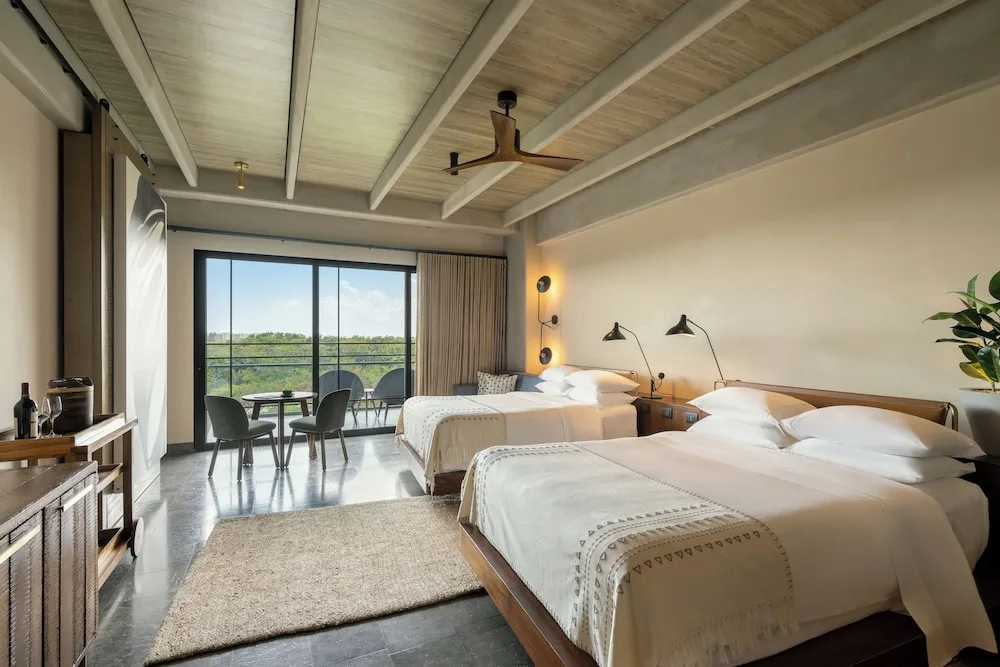 Junior Suite with two beds at Atelier Playa Mujeres featuring a private balcony, contemporary design, and access to full resort amenities.