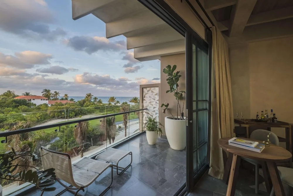 Ocean-view balcony and sitting area in a Junior Suite at Atelier Playa Mujeres.