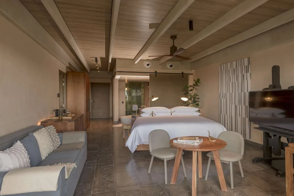 Junior Suite Ocean View guest room with king bed and seating area at Atelier Playa Mujeres.