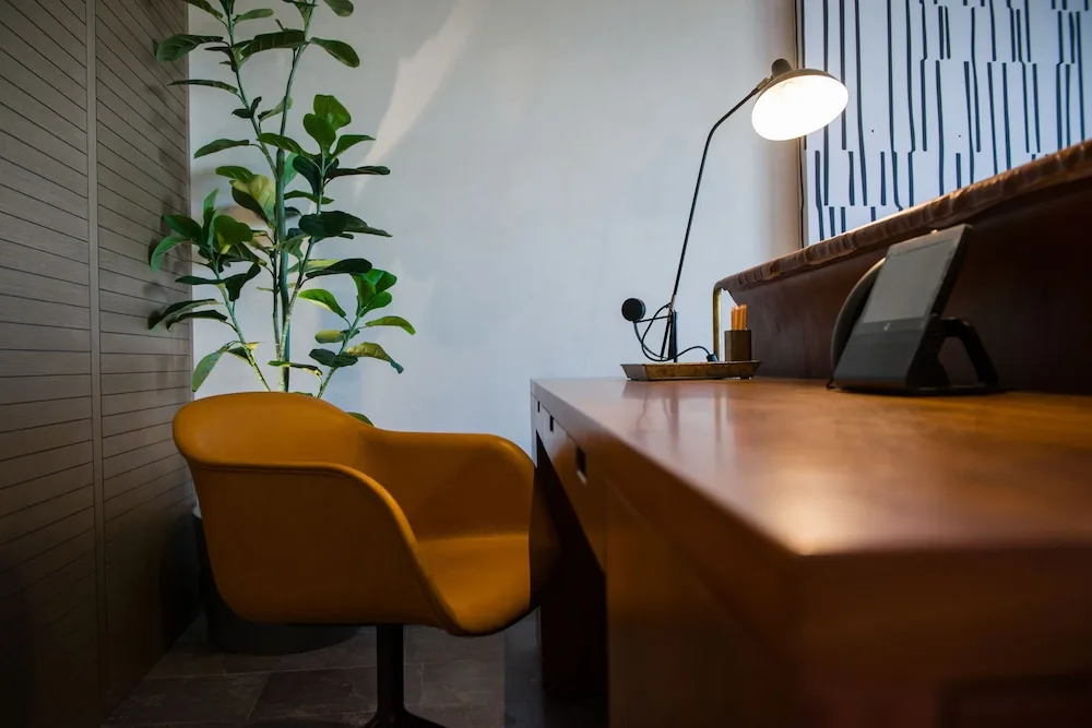 Writing desk and mustard chair in a Wheelchair Accessible Junior Suite at Atelier Playa Mujeres.