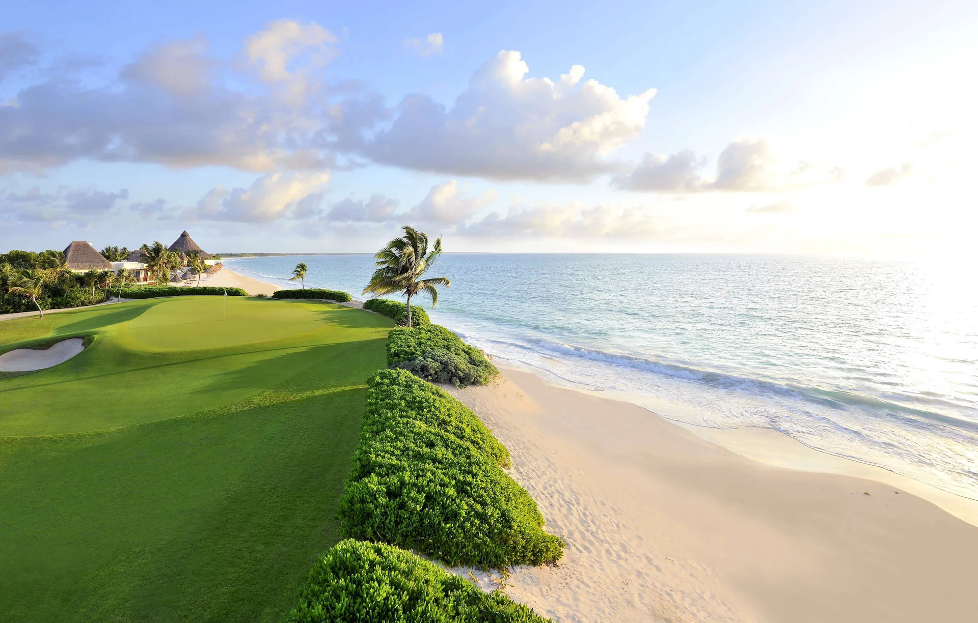 A beachfront golf green borders the Caribbean shoreline at Banyan Tree Mayakoba.